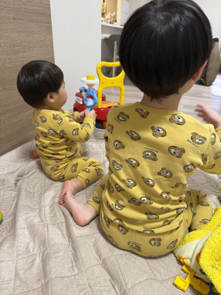 寝室でお揃いパジャマを着ている兄弟の後ろ姿